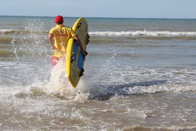 RNLI Lifeguard with board. pic by Kt Bruce SUS-210527-090744001