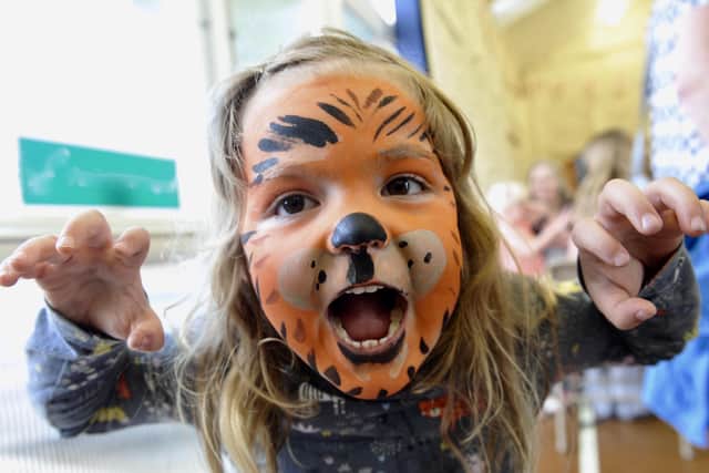 A young girl with her face painted as a tiger