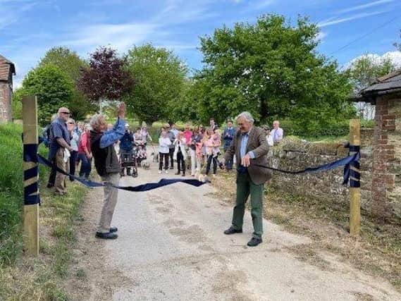 Lord Egremont cuts the ribbon to mark the opening of the new Permissive Footpath SUS-220605-163241001