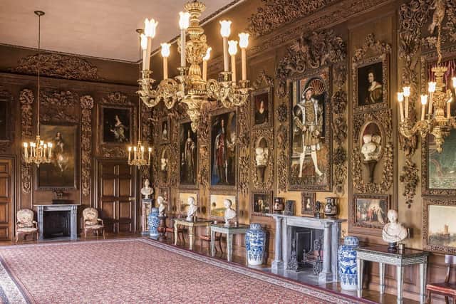 The Carved Room, with the four paintings by Turner restored to the panelling, looking South at Petworth House and Park, West Sussex. The carvings are by Grinling Gibbons. Henry VIII portrait hangs over fireplace. SUS-220328-143226003