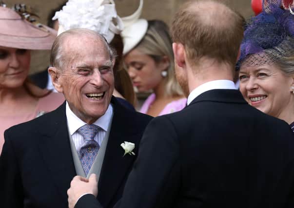 Prince Philip, Duke of Edinburgh reacts as he talks with Britain's Prince Harry, Duke of Sussex as they leave St George's Chapel in Windsor Castle, Windsor (Photo by STEVE PARSONS/POOL/AFP via Getty Images)