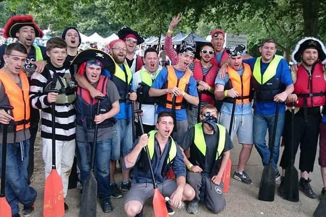 Abob mentors with young men they are helping at a dragon boat race