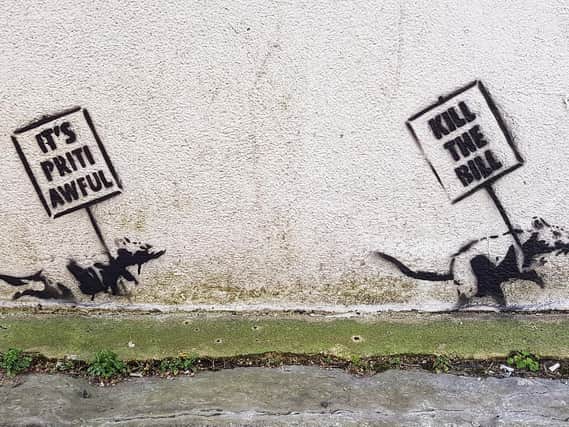 Two stenciled rats holding protest signs. Picture courtesy of Walter Francisco