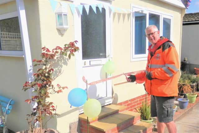 Postman Shaun Sopp cuts the ribbon to officially open the new step at Nik Holland's park home