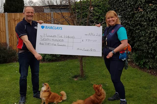 Clare Palmer presents charity manager Alan Chambers with a cheque for £735 for Hounds for Heroes