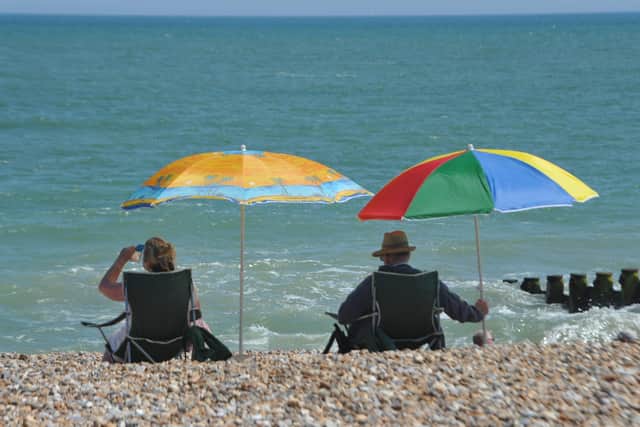 Two people enjoying the sun on Eastbourne Beach. E28176P ENGSUS00120130907113555