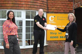 Postmaster Paul Money presents the new laptop to Chestnut Tree House charity shop manager Maryanne Mills, watched by community fundraiser Caroline Roberts-Quigley