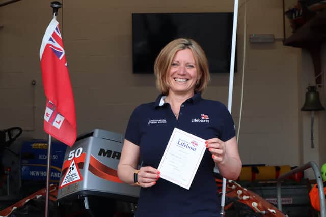 Bea Homer proudly holds her fundraising certificate from 1988 in front of one of Littlehampton's lifeboats. Picture: RNLI/Beth Brooks