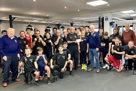 Bognor Regis Lion Simon Knights hands a cheque to coach Dave Larner, alongside other coaches and members of the boxing club