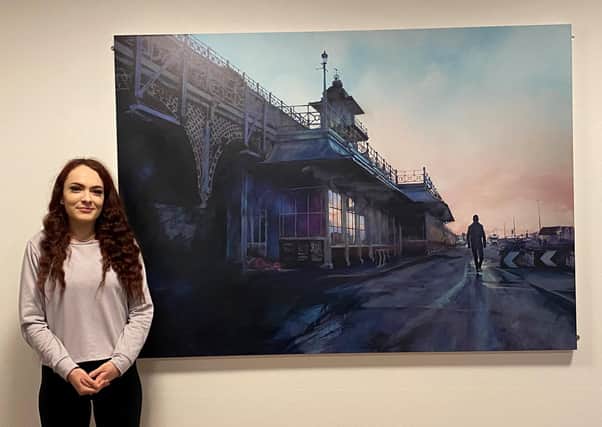 Jade beside a print of one of Tony Mill’s paintings ‘4 Miles Away – The Man Who Sold The World’ at Brighton & Hove Foyer