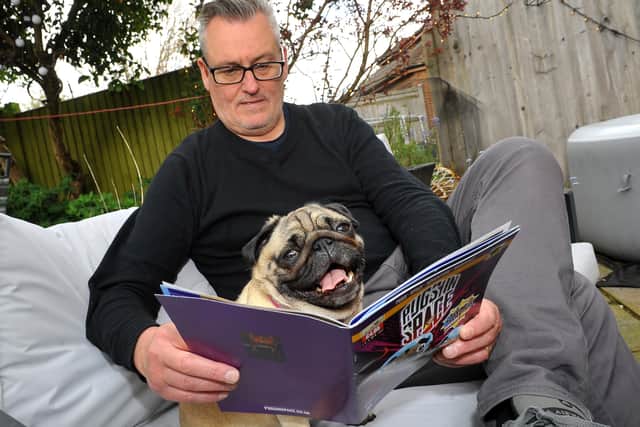 Tim Southwell and one of the pugs have a read of Pugs In Space. Picture: Steve Robards, SR2105272