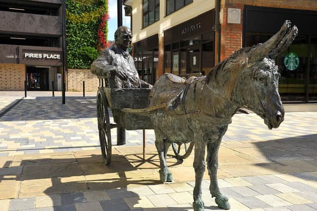 The statue in Piries Place, Horsham, with the car park's green wall behind it. Pic by Steve Robards