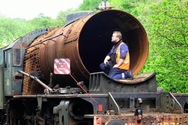Apprentice Mark Readman checking out the boiler on the rusting Dame Vera Lynn parked up in a siding near the sheds at Grosmont on the North York Moors Railway