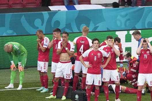 Denmark players are distraught as Christian Eriksen receives treatment on the pitch