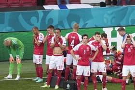 Denmark players are distraught as Christian Eriksen receives treatment on the pitch