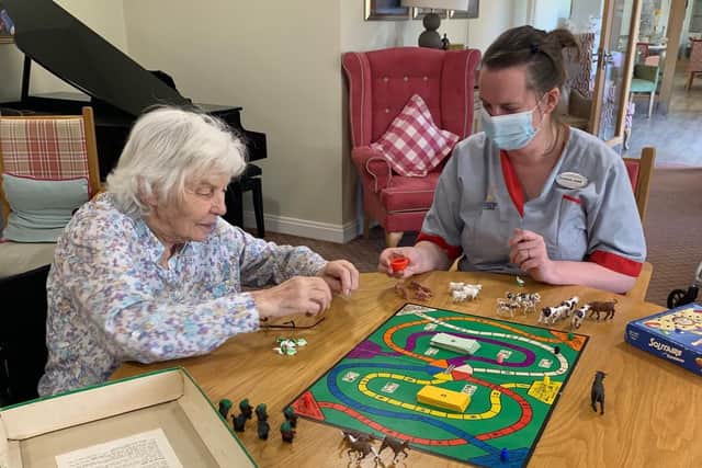 Jenny Mitchell-Jones familiarises herself with Market Day again nearly 50 years after she and friends invented the game. Helping her is Sarah-jane Willis, Companionship team member at Colten Care’s Chichester care home Wellington Grange