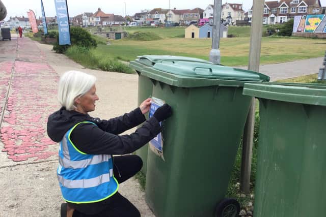 Wendy Peters, of Keep Lancing Lovely, installs bin posters to support Adur and Worthing Councils litter crackdown