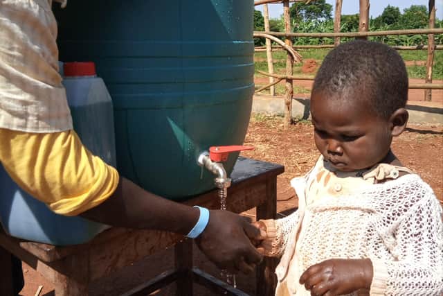 A little one being shown handwashing thanks to The Busoga Trust SUS-210628-150535001