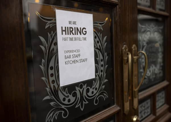 A "We are hiring" sign is seen in the window of a pub seeking bar and kitchen staff  (Photo by Rob Pinney/Getty Images) SUS-210907-082515001
