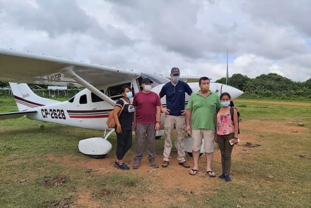 The small plane and team at the landing strip with the first batch of vaccines SUS-211207-131543001