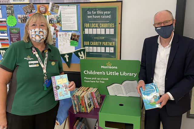 Alison Whitburn, community champion at Morrisons Littlehampton, shows Littlehampton MP Nick Gibb the store's new Children's Little Library