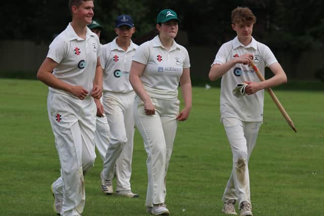Young Bradley Bover (right) leads Lindfield CC 3rd XI off after their win over Scaynes Hill CC 2nd XI