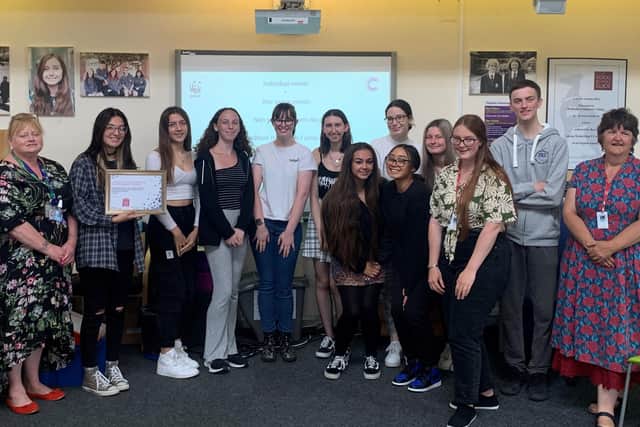 Sixth form students with a certificate of thanks from Cancer Research UK