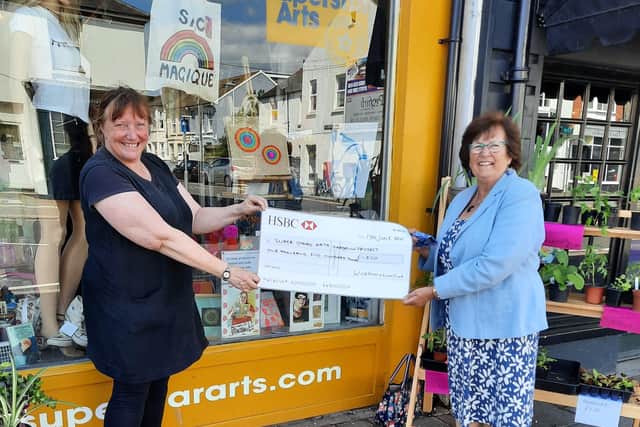 Worthing Lions past president Hazel Thorpe presents a cheque for £1,500 to Jo Telling from Superstar Arts outside its charity shop near West Worthing railway station