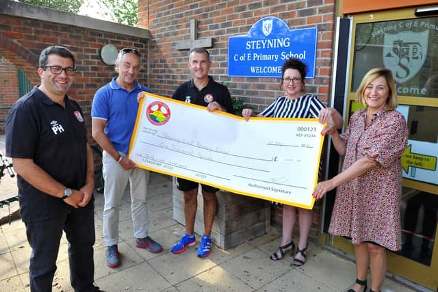Steyning Town Community FC outgoing tournament co-ordinator Paul Hart, chairman Ian Nichols and youth co-ordinator Adrian Ridley present the cheque for £1,000 to Steyning Primary School headteacher Sue Harrison and business manager Debbie Taylor. Picture: Steve Robards SR2107144