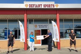 PCSO Agnew handing over the donation to Defiant Sports. Picture from Sussex Police. SUS-210723-104019001
