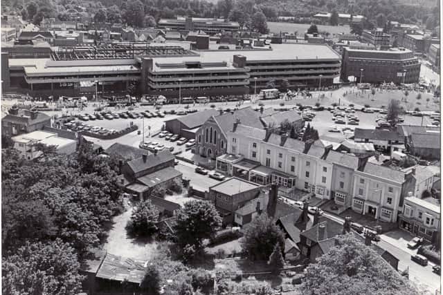 Aerial picture of Horsham from September 1983, looking towards Albion Way, during construction of Swan Walk and the multi-storey car park, with a carnival procession underway