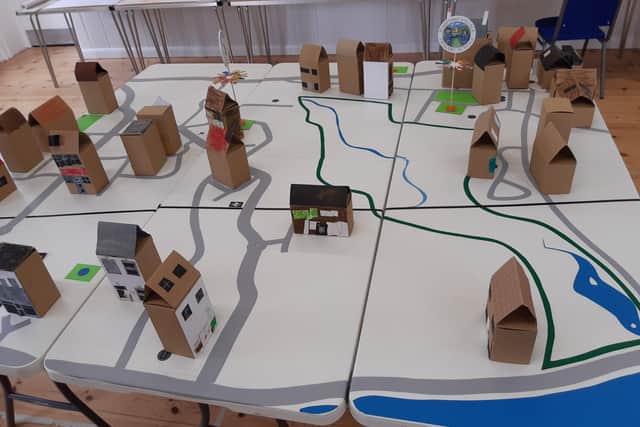A 3D table-top map of the area around the new river site, with model houses made by the children