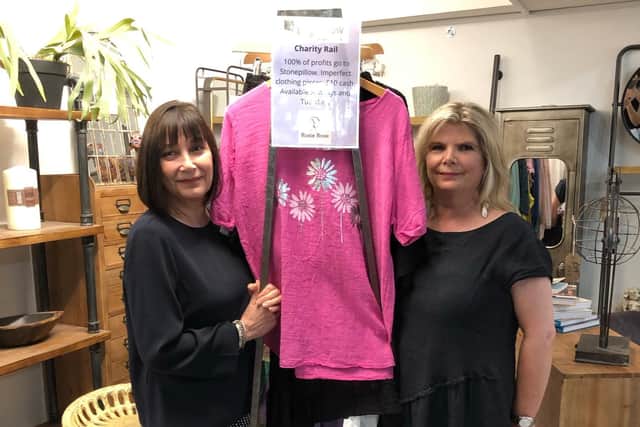 Rosie Rose store manager Sarah Dinwiddy and her colleague Marion Chambers standing with the Stonepillow Charity Clothes Rail that comes out in store on Tuesdays and Sundays