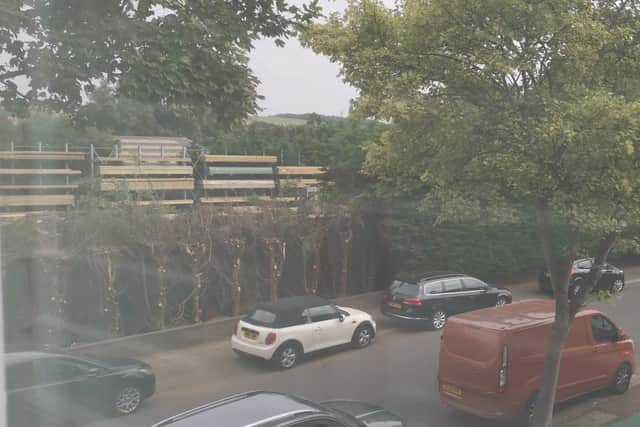 Michelle Ryan's view from her home in Southdownview Road, Worthing, of the cut back hedge exposing the building merchants, Parkers