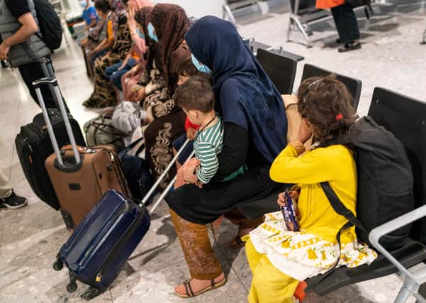 Afghan refugees arrive in Heathrow (Photo by DOMINIC LIPINSKI/POOL/AFP via Getty Images)