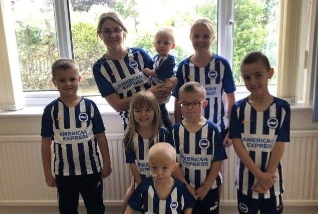 George with his seven siblings, all pictured together wearing the Brighton and Hove Albion football kit
