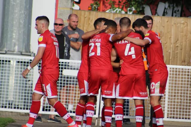 Crawley Town players celebrate with matchwinner Nick Tsaroulla. Picture by Cory Pickford