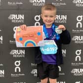 Axton Powell with his medal and certificate for finishing Run Reigate