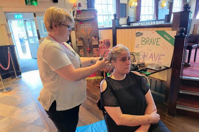 Tracy McBride has her hair shaved by Air Balloon manager Sarah Gibson