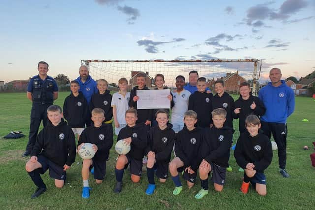 Eastbourne United under-12s with the £500 cheque. Picture from Sussex Police SUS-210510-121930001