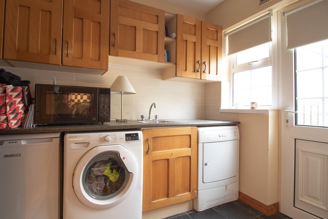 The utility room has high and low level units and has a practical fully tiled floor.
