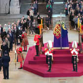 Members of the public file past the coffin of Queen Elizabeth II, draped in the Royal Standard with the Imperial State Crown and the Sovereign's orb and sceptre, lying in state on the catafalque in Westminster Hall, at the Palace of Westminster, London, ahead of her funeral on Monday. Picture: Yui Mok/PA Wire