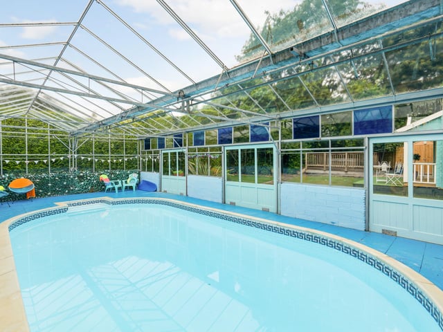 The home also has an outdoor swimming pool with a cover
