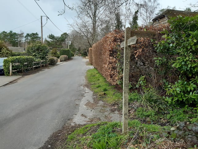 Continue to follow this road, going past this footpath sign on the right