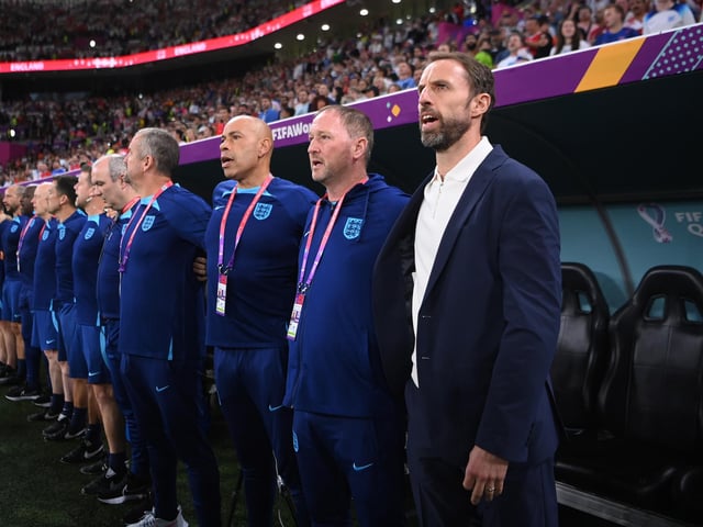 DOHA, QATAR - NOVEMBER 29: Gareth Southgate, Head Coach of England, and his team staffs line up for the national anthem prior to the FIFA World Cup Qatar 2022 Group B match between Wales and England at Ahmad Bin Ali Stadium on November 29, 2022 in Doha, Qatar. (Photo by Laurence Griffiths/Getty Images)