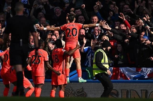 Brighton's Paraguayan striker Julio Enciso (C) celebrates with teammates in front of fans after scoring their second goal at Chelsea