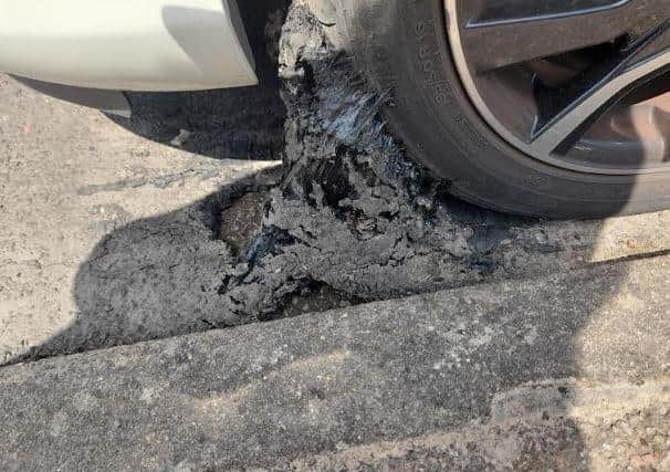 Large chunks of tarmac stuck to the wheel of a Toyota Yaris after it sank into tarmac on a Horsham road