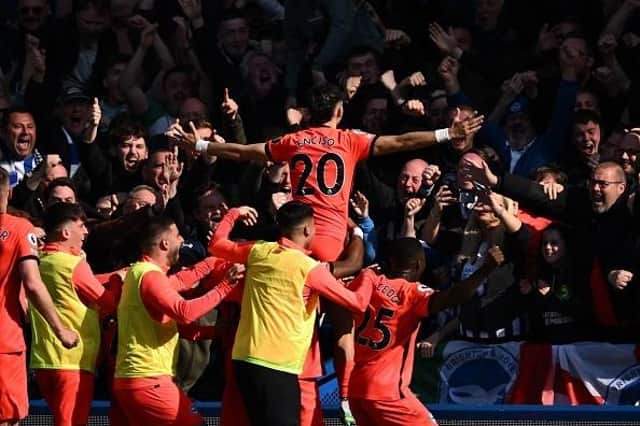 Brighton's Paraguayan striker Julio Enciso (C) celebrates with teammates in front of fans after scoring their second goal at Chelsea
