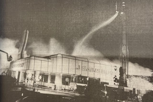 A lone fireman battles with the flames from above as they spread through the roof.