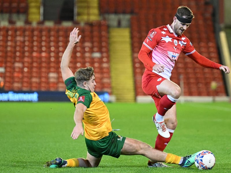Charlie Hester-Cook of Horsham challenges Jamie McCart of Barnsley for the ball during the Emirates FA Cup First Round match between Barnsley and Horsham at Oakwell Stadium.